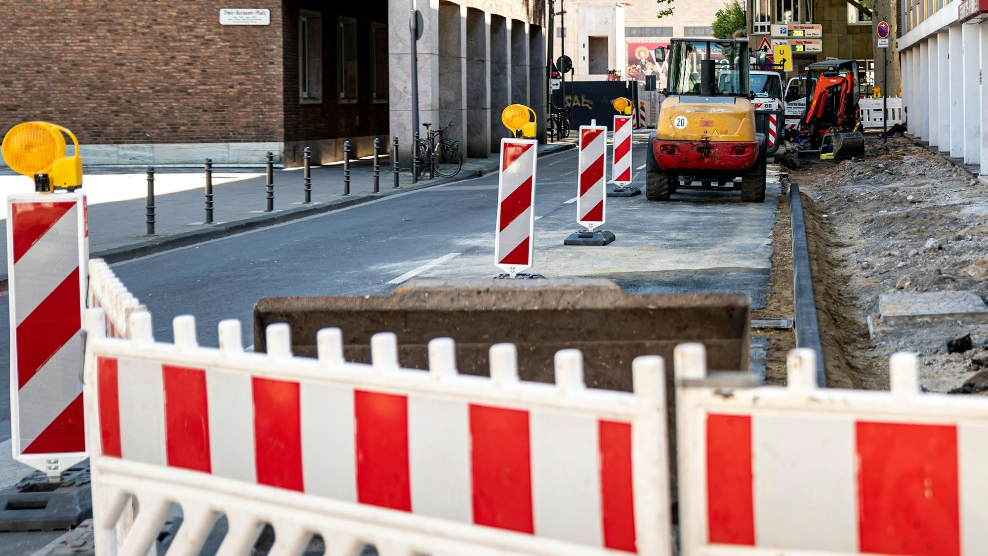 Auf dem Foto sind ein aufgerissener Bürgersteig und rot-weiße Absperrschilder zu sehen.