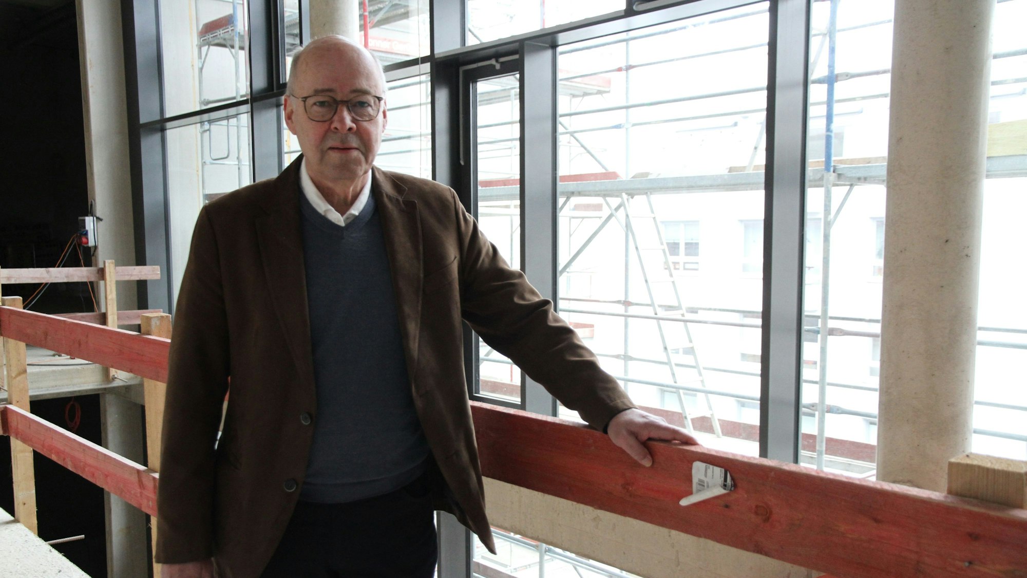 Ein man an einem hölzernen Treppengeländer in einer Baustelle