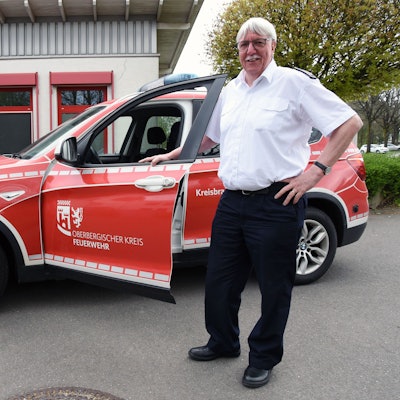 Der scheidende Kreisbrandmeister Wilfried Fischer steht an einem Einsatzwagen vor der Leitstelle des Oberbergischen Kreises in Gummersbach.
