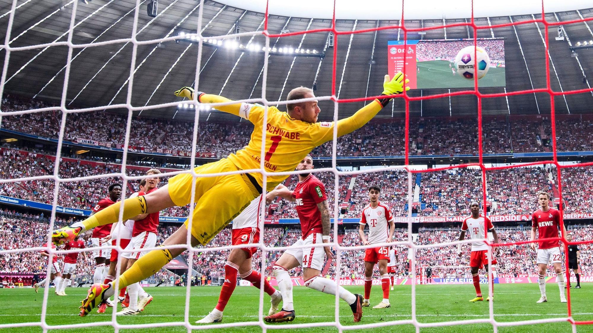 Münchens Raphael Guerreiro erzielt aus der Distanz das 1:0, Kölns Torwart Marvin Schwäbe streckt sich vergeblich.