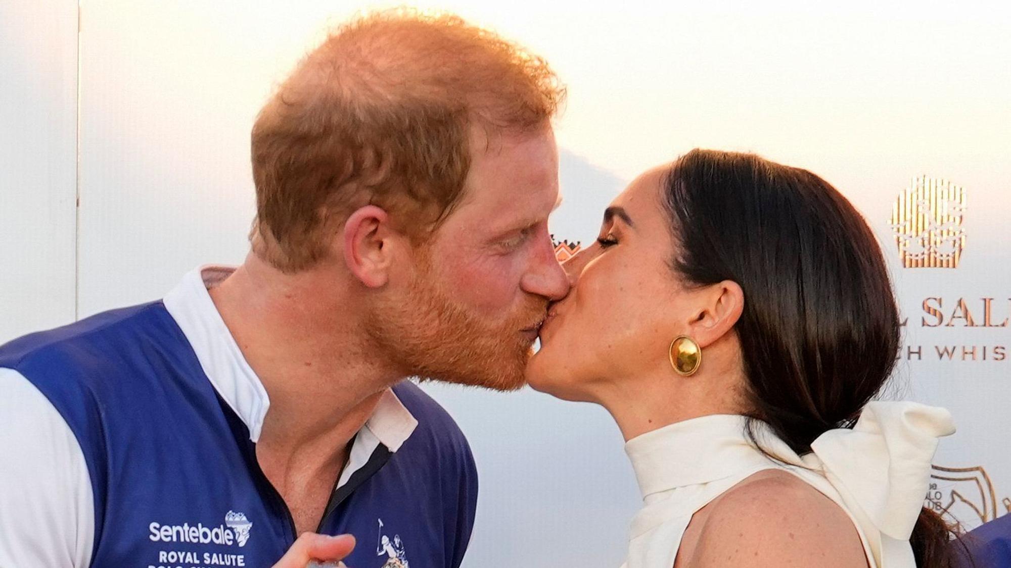 Prinz Harry (l) und seine Frau Meghan, Herzogin von Sussex, küssen sich nach einem Polo-Charity-Turnier.