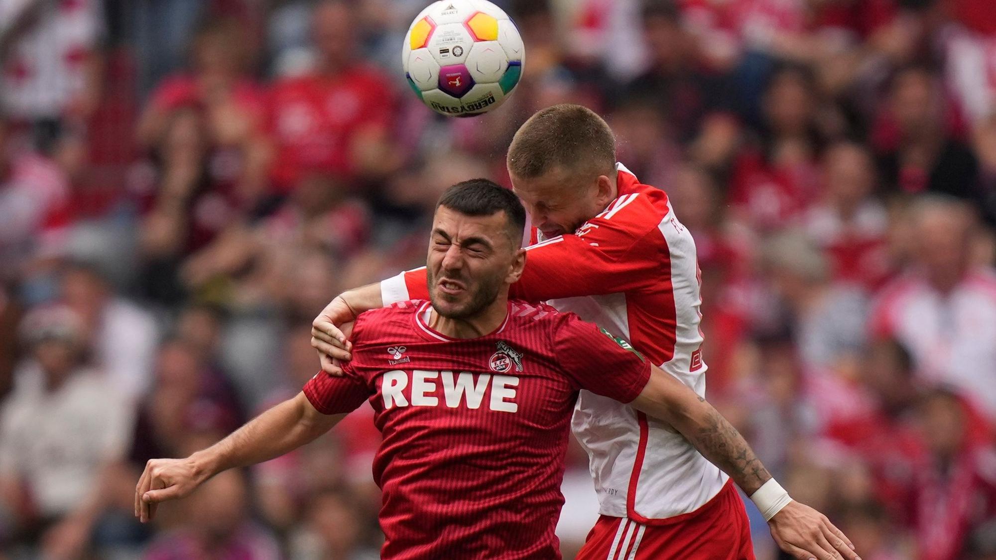Cologne's Sargis Adamyan, left, jumps for a header with Bayern's Eric Dier during the German Bundesliga soccer match between Bayern Munich and Cologne at the Allianz Arena in Munich, Germany, Saturday, April 13, 2024. (AP Photo/Matthias Schrader)
