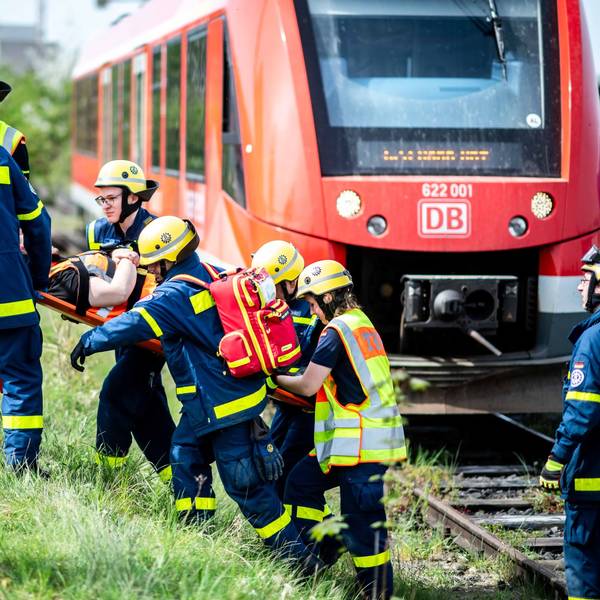 Das Bild zeigt einige Mitarbeiter des THW, die eine verletzte Person eine Böschung hinauf tragen.