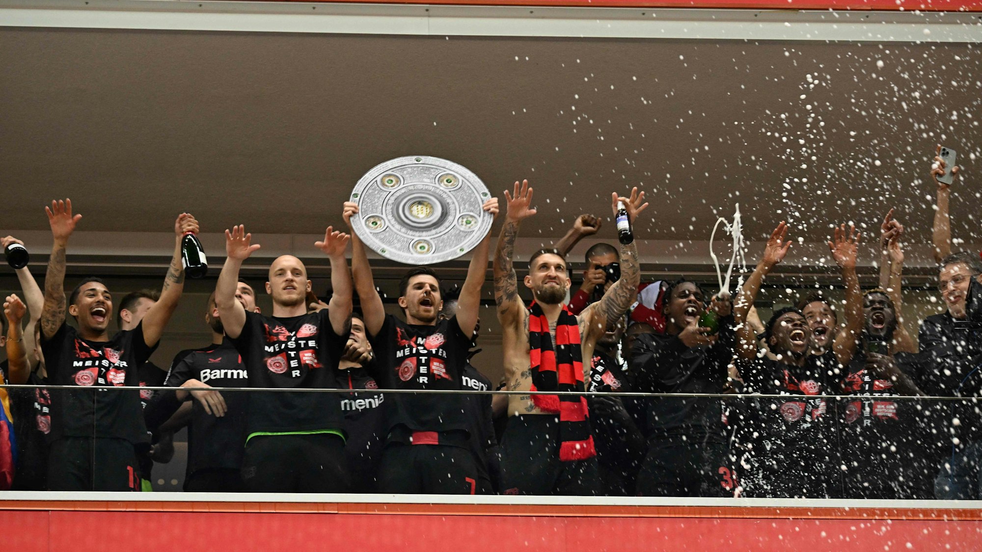 Die Bayer-Profis jubeln auf dem Balkon einer Loge hinunter zu den Fans.