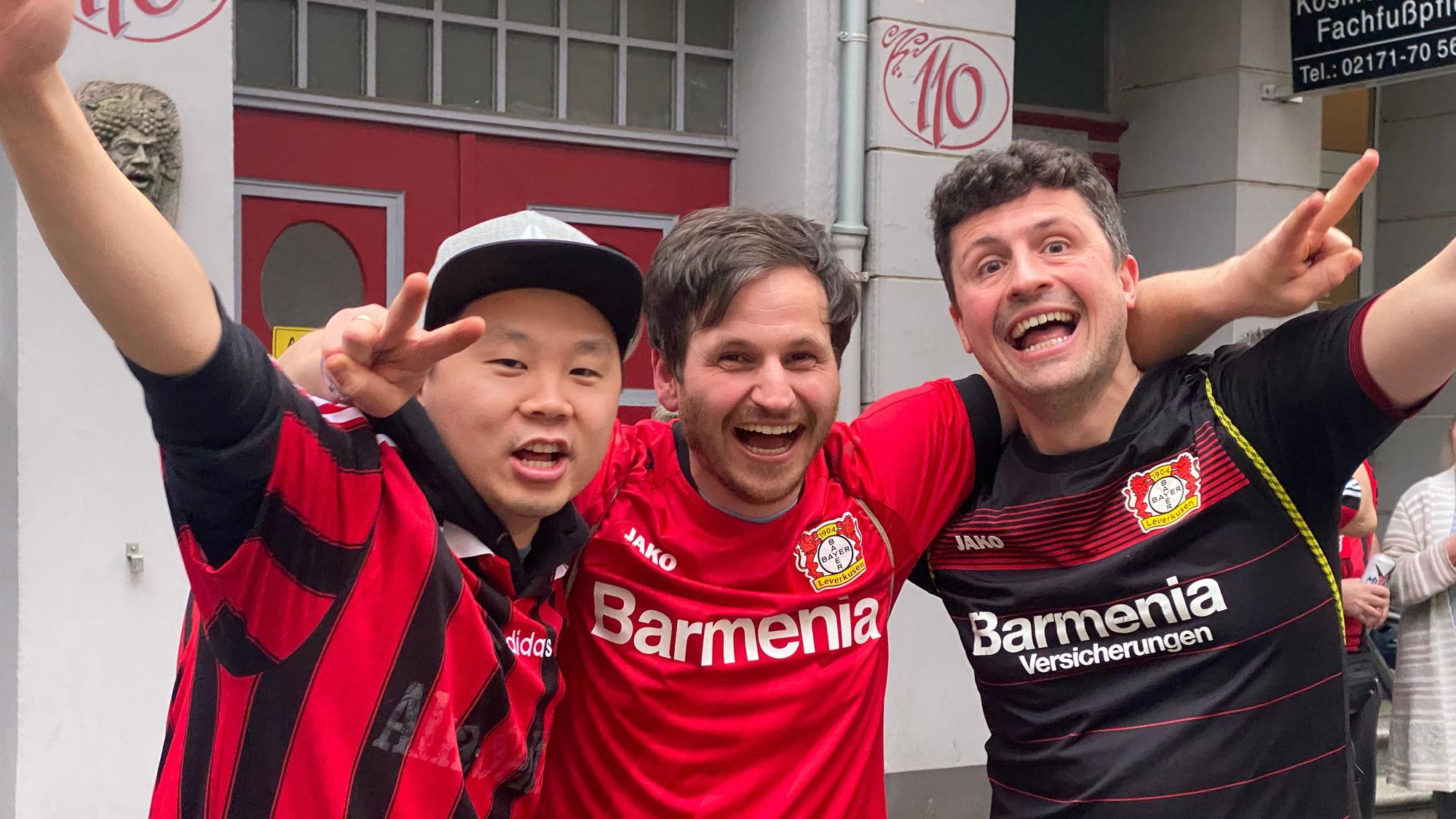 Die Bayer-Fans Benni, Vito und Fu bejubeln die Leverkusener Meisterschaft.