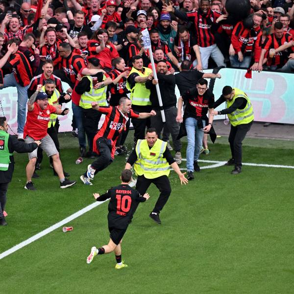 Leverkusens Florian Wirtz dreht nach seinem Tor zum 4:0 jubelnd ab und beruhigt Fans und Sicherheitspersonal, die auf das Spielfeld laufen.