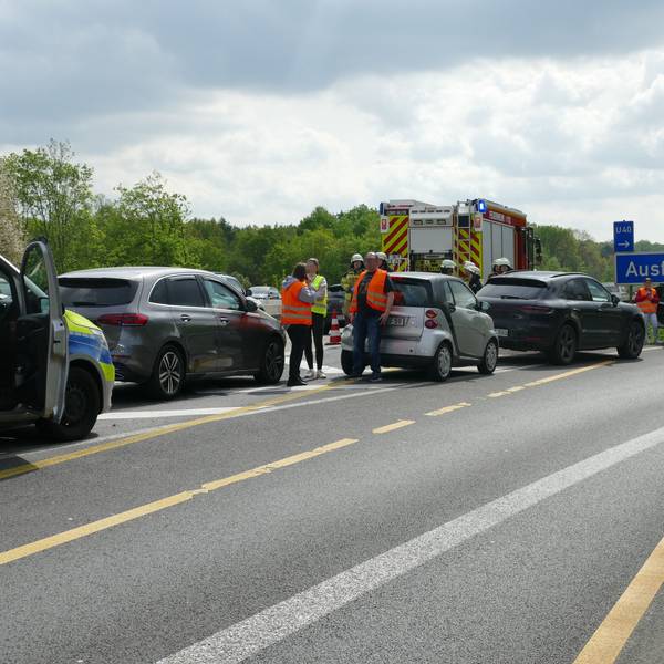 Mehrere Fahrzeuge stehen auf der Fahrspur der Ausfahrt, dazwischen Menschen mit Warnwesten.