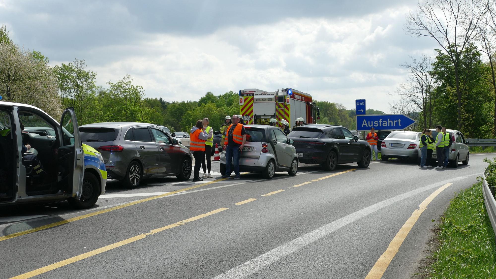 Mehrere Fahrzeuge stehen auf der Fahrspur der Ausfahrt, dazwischen Menschen mit Warnwesten.