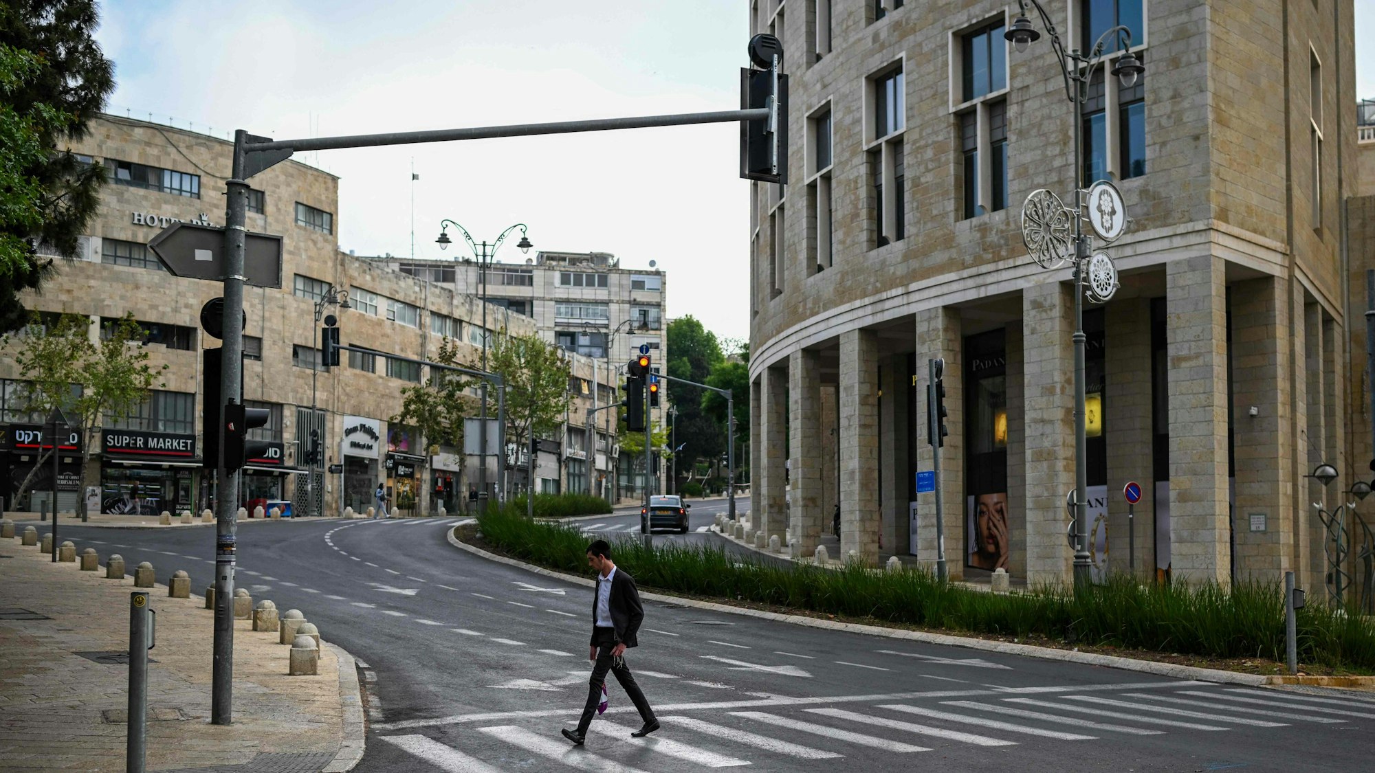 Ein einsamer Passant läuft über eine Straße in Jerusalem. Die Stadt ist am 14. April wie ausgestorben.