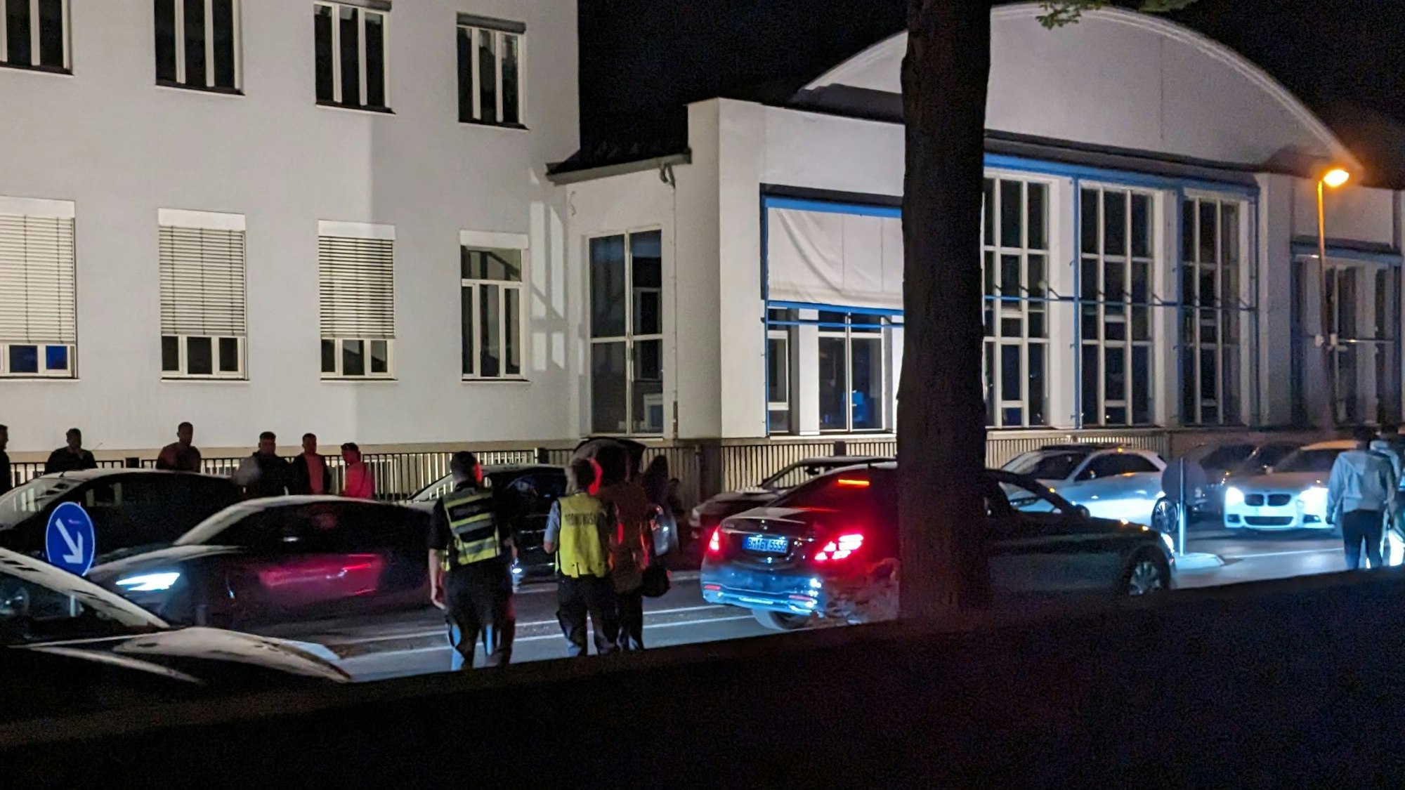 Die Alfred-Schütte-Allee bei Nacht. Das Ordnungsamt patrouilliert auf der Allee, am Straßenrand stehen die Autos der Raser- und Poserszene Kölns. Foto von Florian Holler