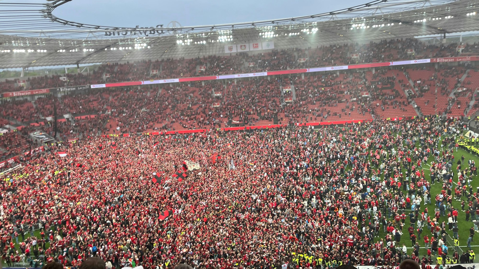 Leverkusens Fans bejubeln auf dem Rasen den Gewinn der Deutschen Meisterschaft.