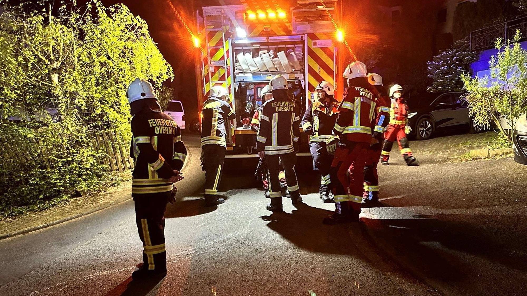 Feuerwehrleute stehen um ein Einsatzfahrzeug.