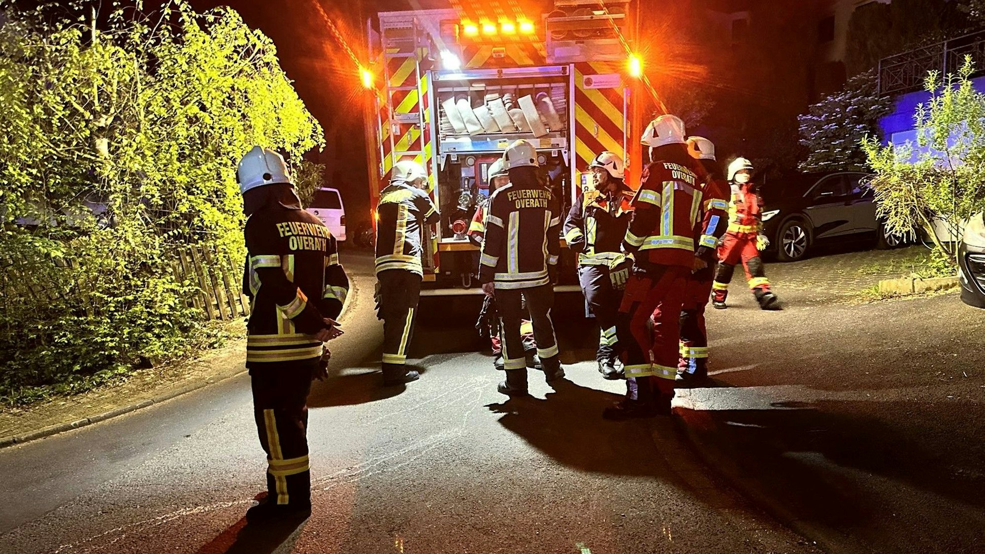 Feuerwehrleute stehen um ein Einsatzfahrzeug.