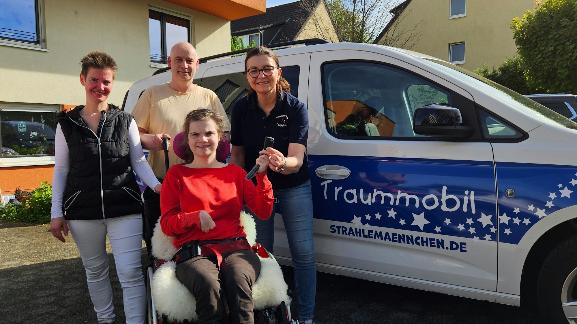 Auf dem Bild sind Laura und ihre Eltern zu sehen, die von der Mitgründerin des Vereins Strahlemännchen ein Auto leihweise zu Verfügung gestellt bekommn.