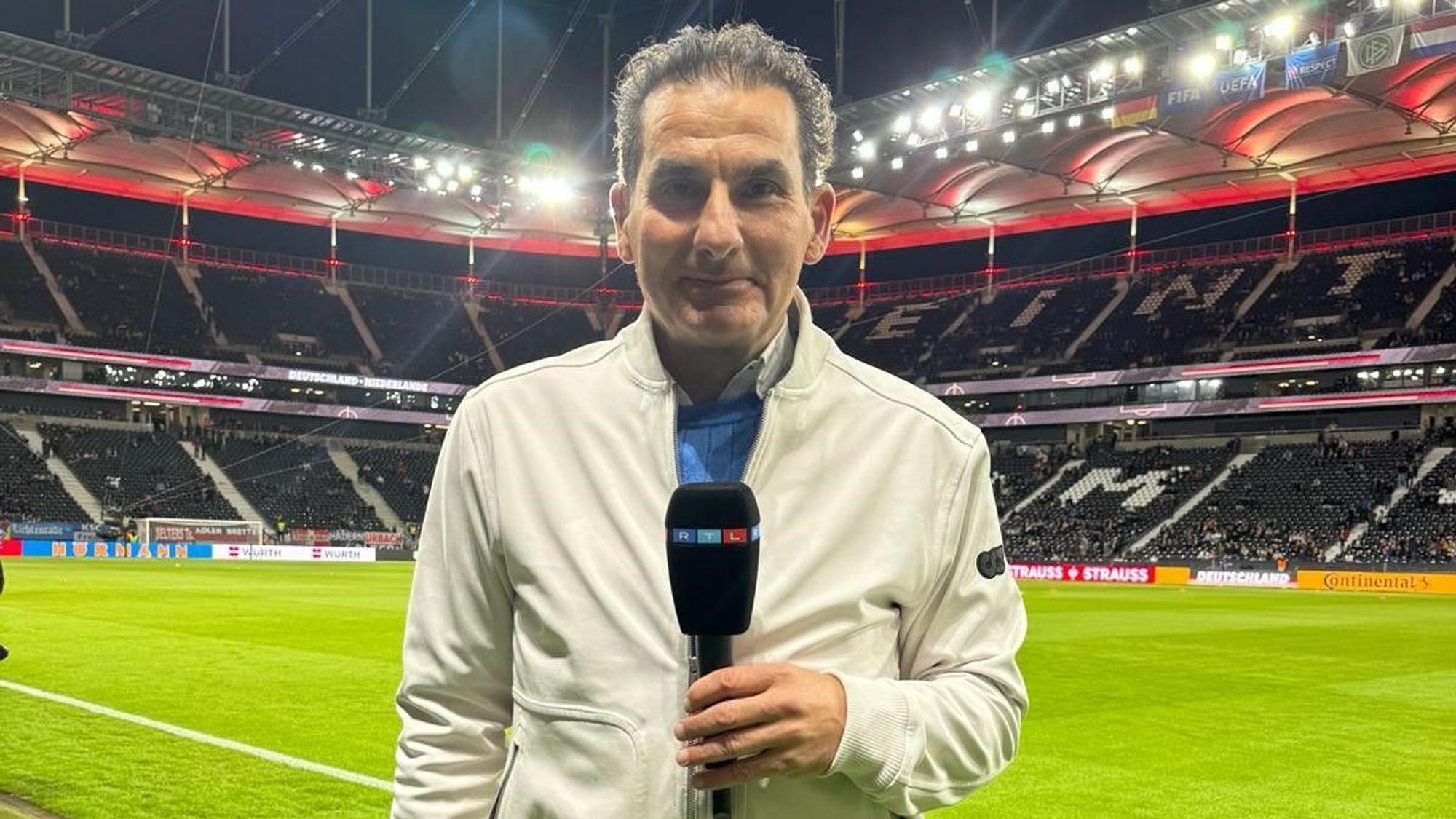 RTL-Sportreporter Felix Görner steht mit einem Mikrofon in einem Stadion.