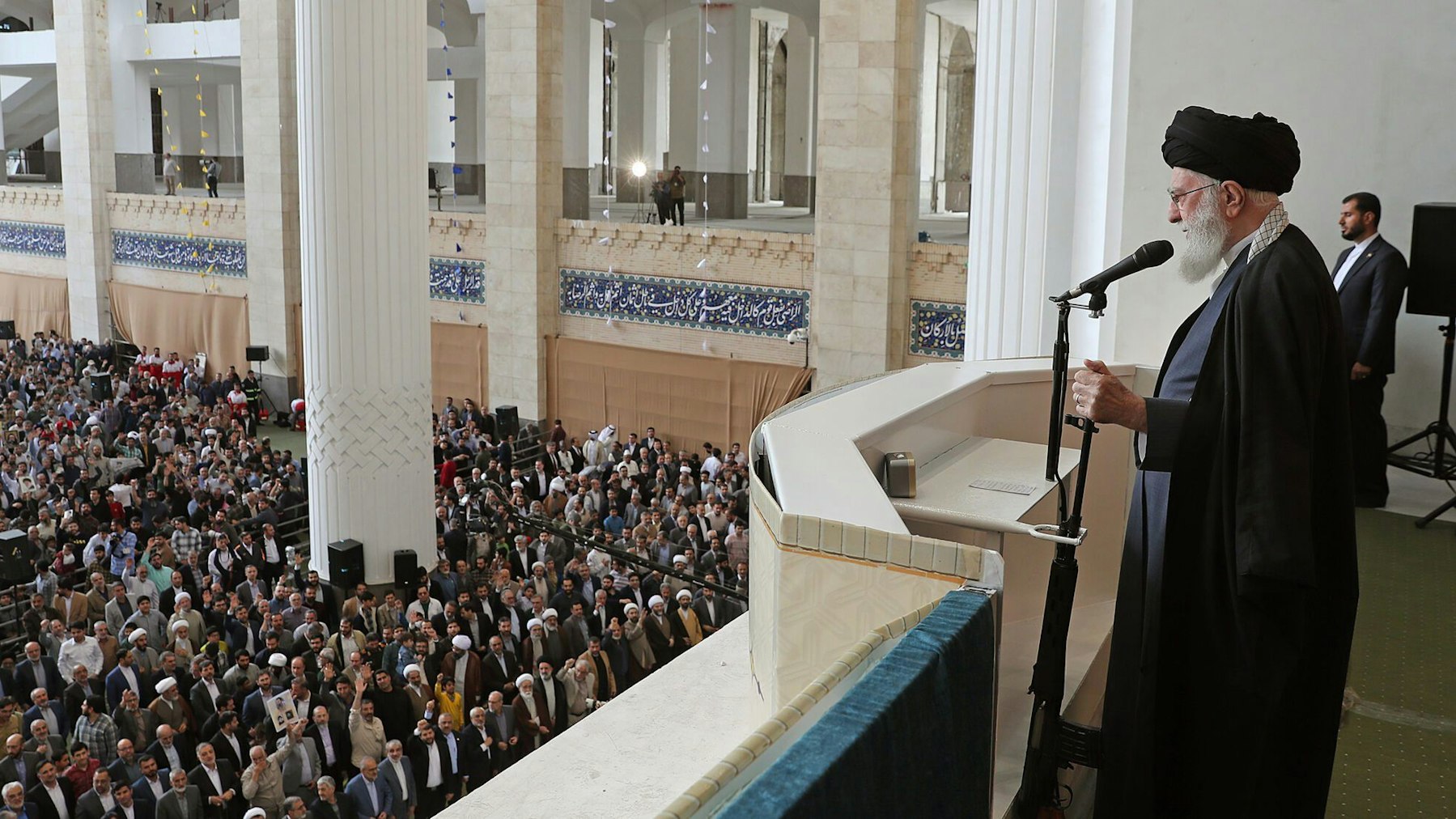 Ajatollah Ali Chamenei leitet das Eid al-Fitr-Gebet und hält bei seiner Rede den Lauf eines Gewehrs in der Hand.