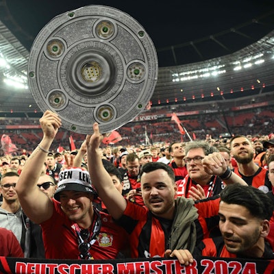 Bayer Leverkusen Fans mit Meisterschale auf dem Stadionrasen