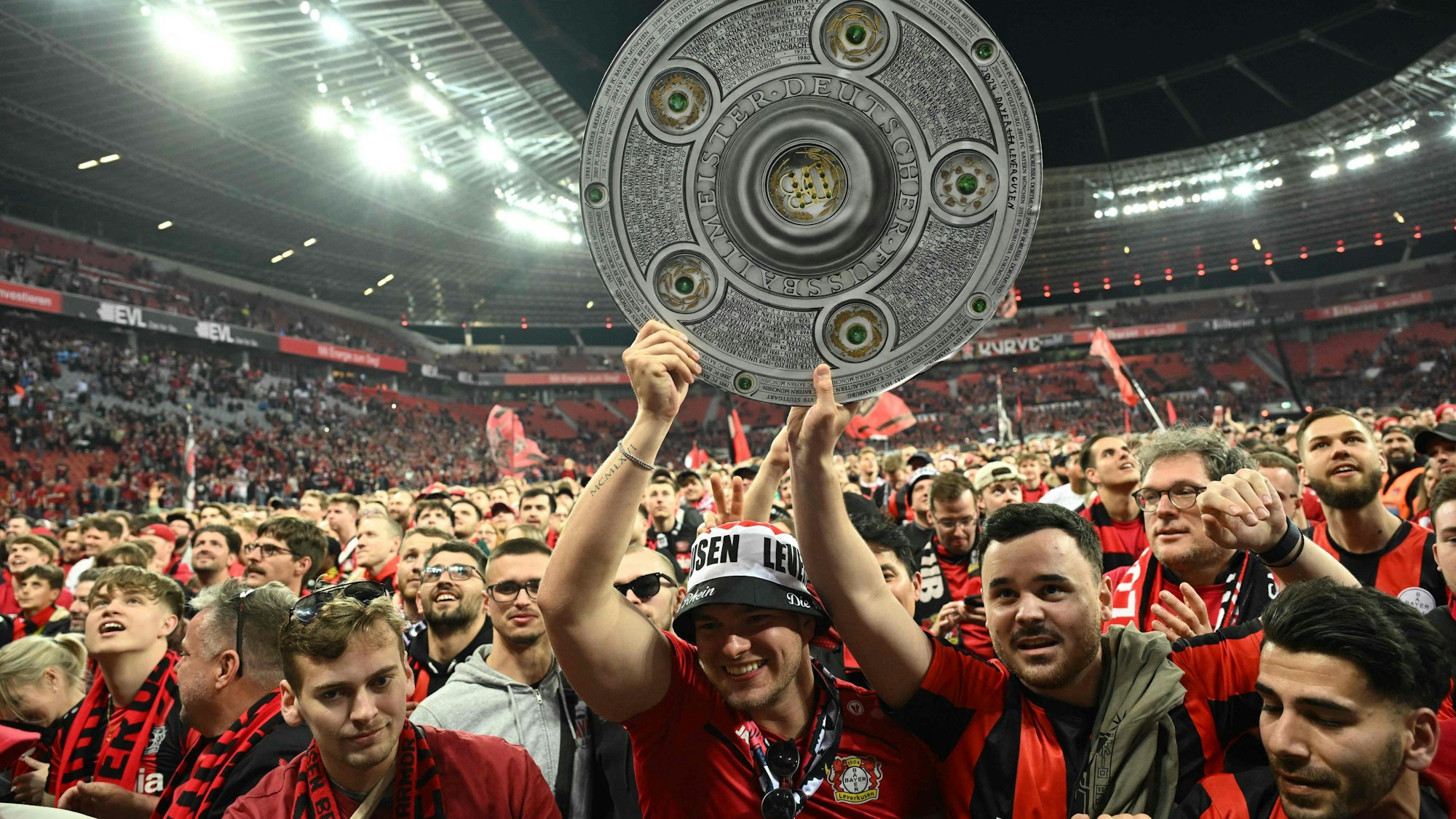 Bayer Leverkusen Fans mit Meisterschale auf dem Stadionrasen