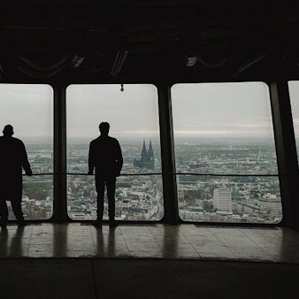 Zwei Silhouetten von hinten mit Ausblick auf Köln aus dem Colonius.