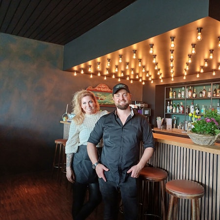 Eine Frau und ein Mann stehen in einem Restaurant an einem Tresen.