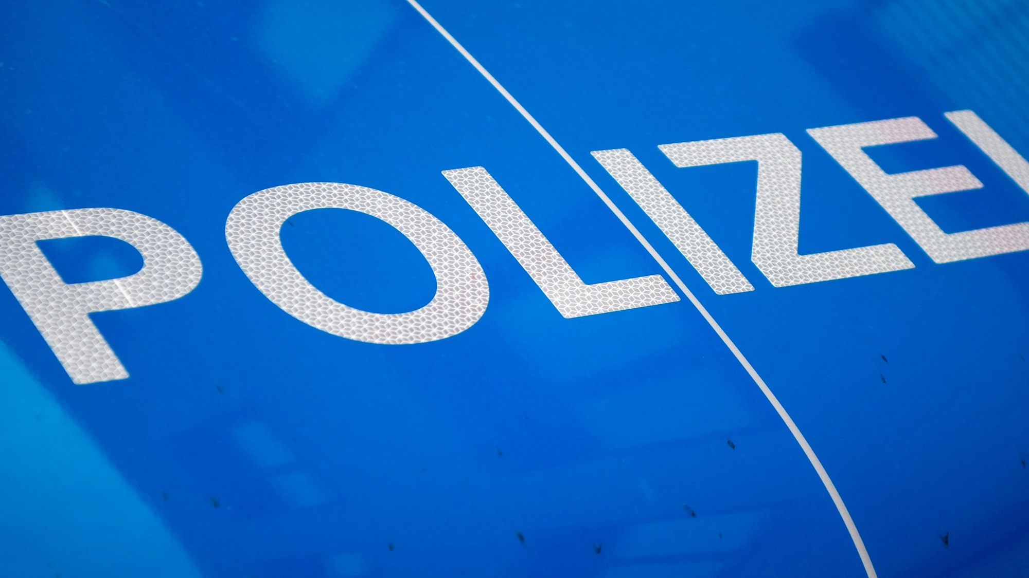 Das Symbolfoto zeigt die Aufschrift „Polizei“ auf einem Wagen.