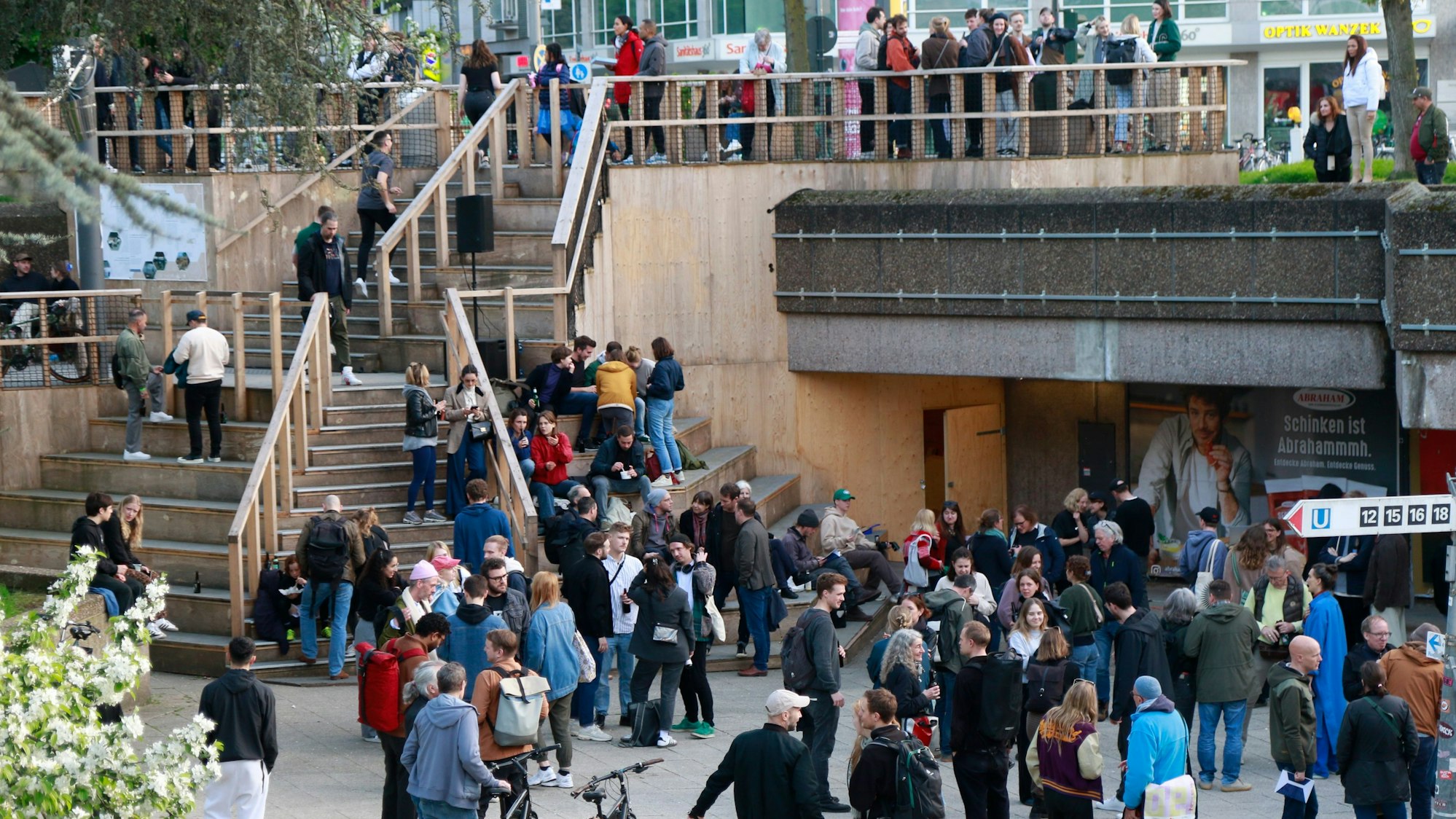 Zu sehen ist die Freitreppe am Ebertplatz in der Vorderansicht und eine große Menschenansammlung.