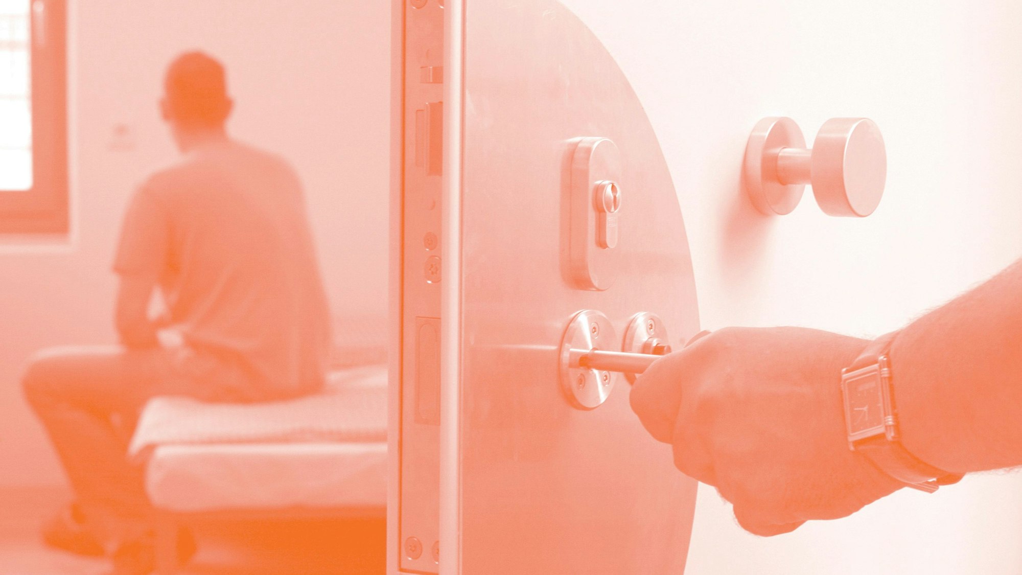 Ein Justizbeamter schließt einen Häftling in seinen Haftraum in einer  Jugendhaftanstalt ein.