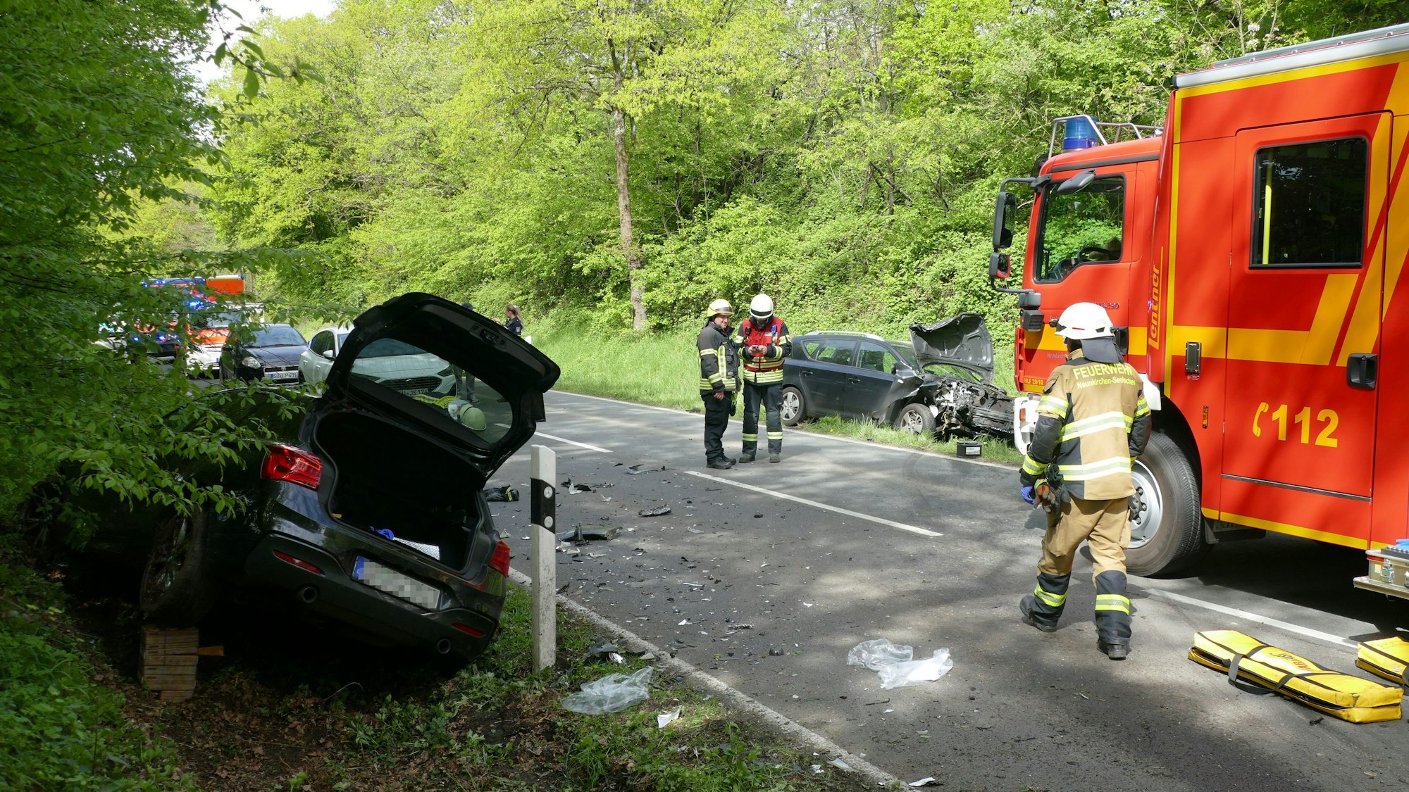 Zwei Autos liegen zerstört im Straßengraben.