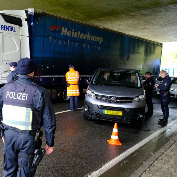 Beamte aus Deutschland und Belgien an einer gemeinsamen Kontrollstelle der Polizei an der B51 bei Dahlem-Baasem. Ein Lastwagen fährt vorbei, Polizisten stehen an einem Kleinbus mit luxemburgischen Kennzeichen.
