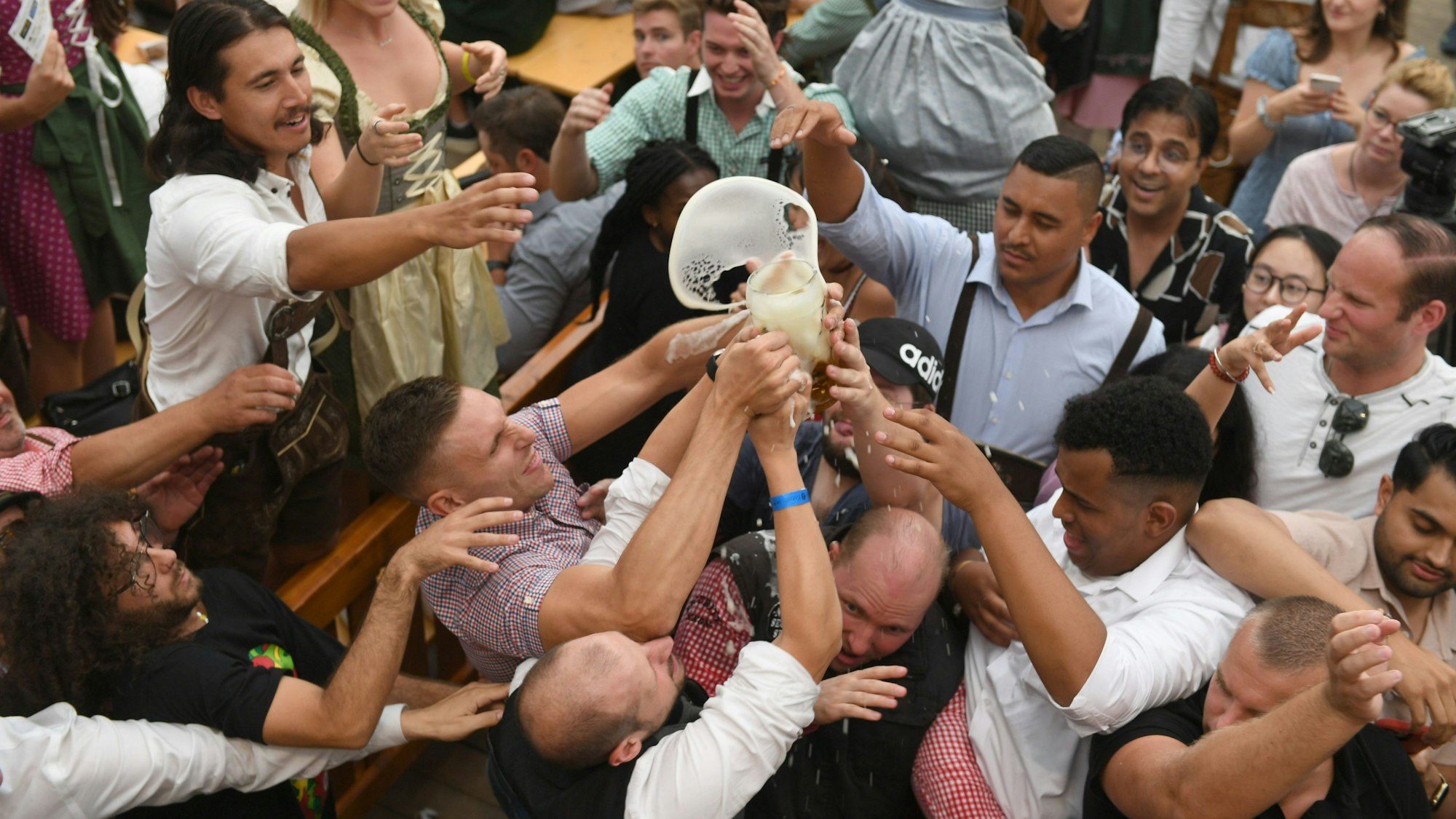 Gäste ringen beim Oktoberfest um eine Maß Bier. Die CSU hat durchgesetzt, dass auch künftig der Cannabis-Konsum auf bayerischen Volksfesten verboten ist. (Symbolbild)