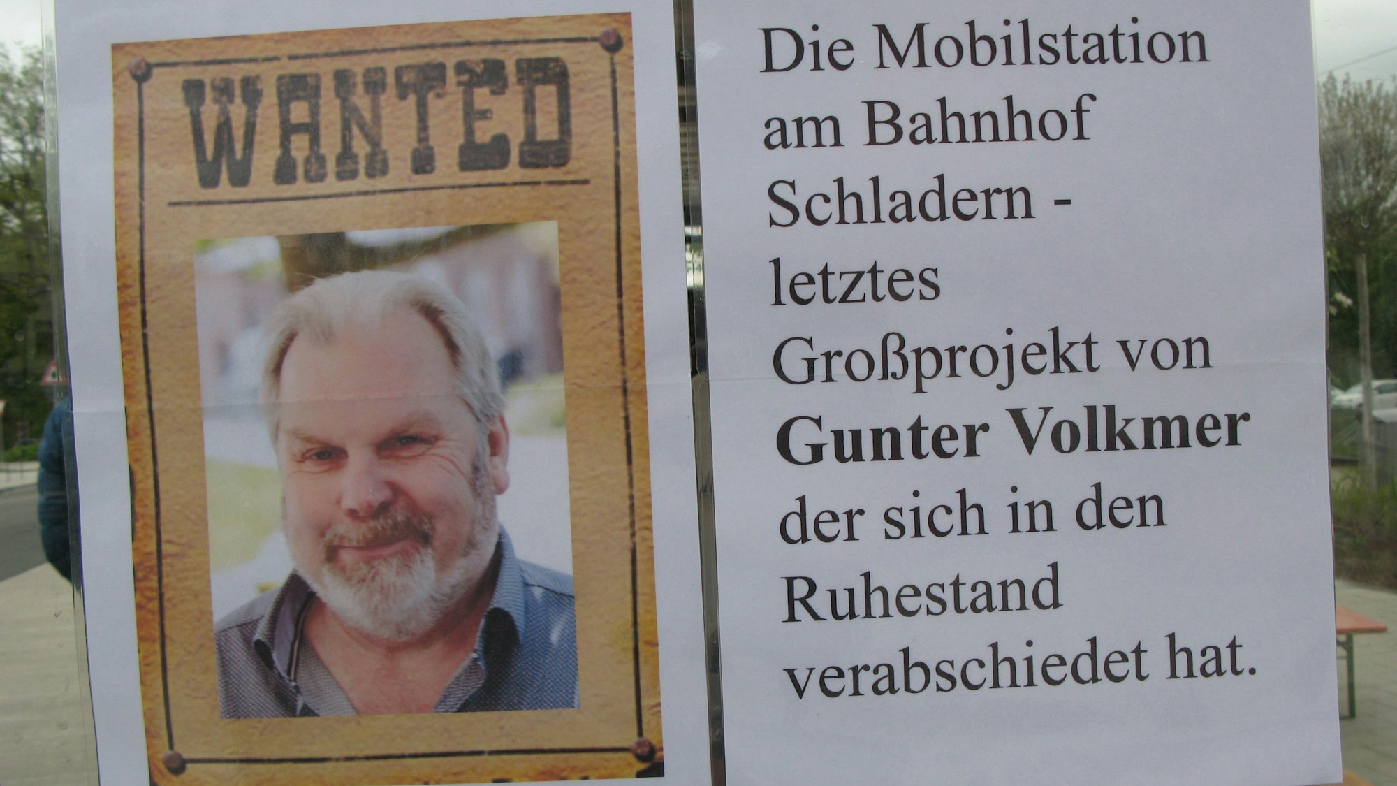 Unter dem Titel „Wanted“ im Stil eines Wild-West-Steckbriefs ist das Porträt eines Mannes mit Bart zu sehen. Auf einem Zettel daneben heißt es: Die Mobilstation auf Bahnhof Schladern - letztes Großprojekt von Gunter Volkmer, der sich in den Ruhestand verabschiedet hat.
