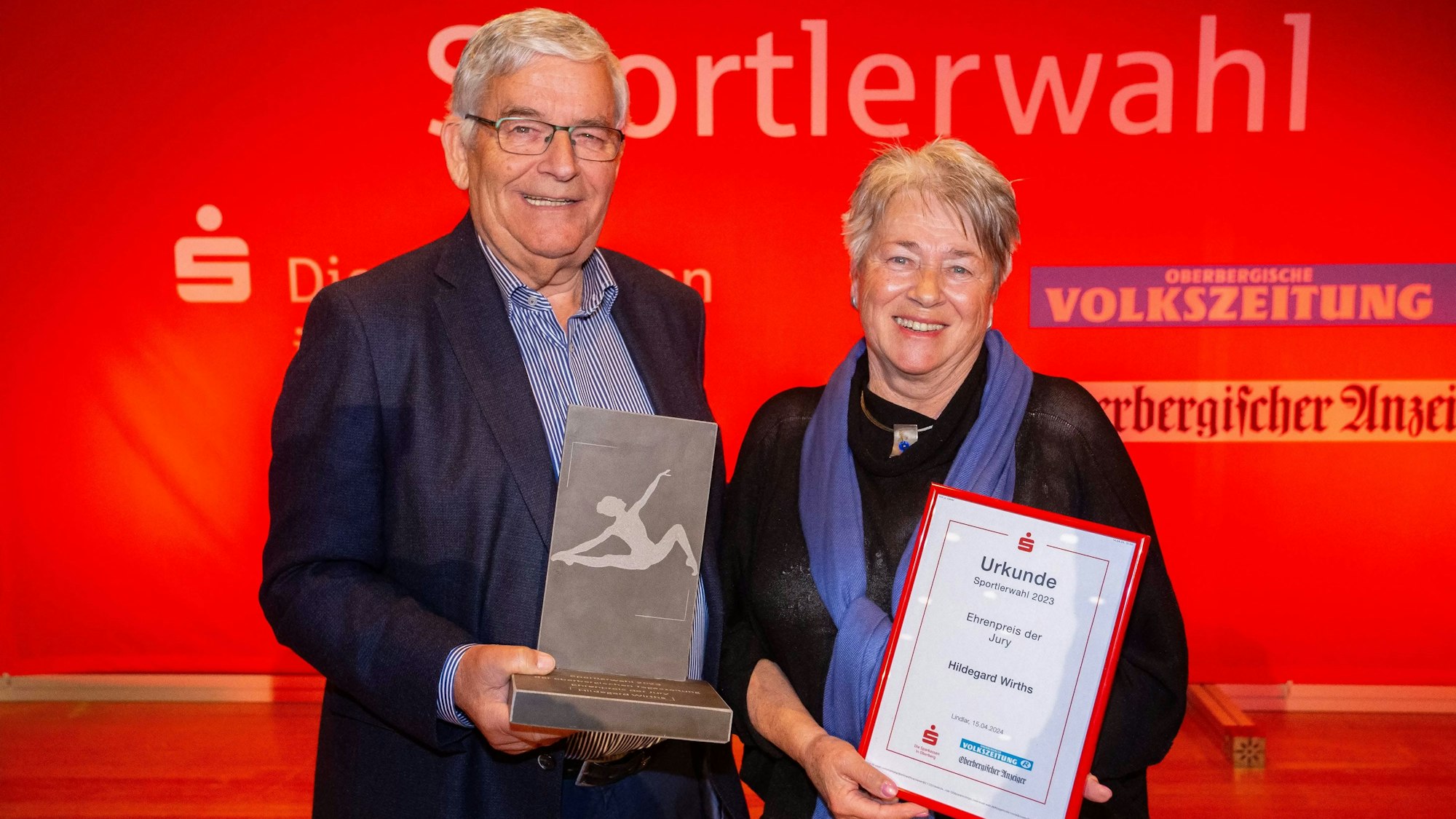 Hagen Jobi überreicht Hildegard Wirths eine Urkunde und eine Skulptur aus Grauwacke.