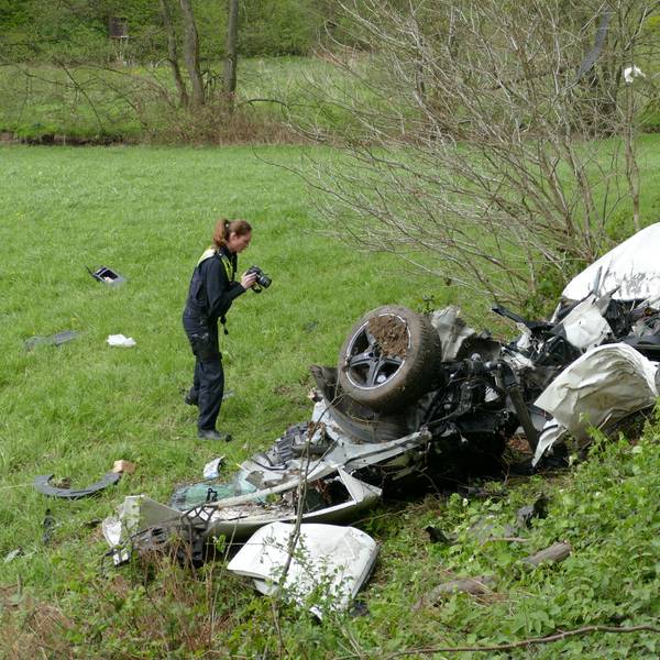 Polizeibeamte untersuchen das Unfallwrack in Much.