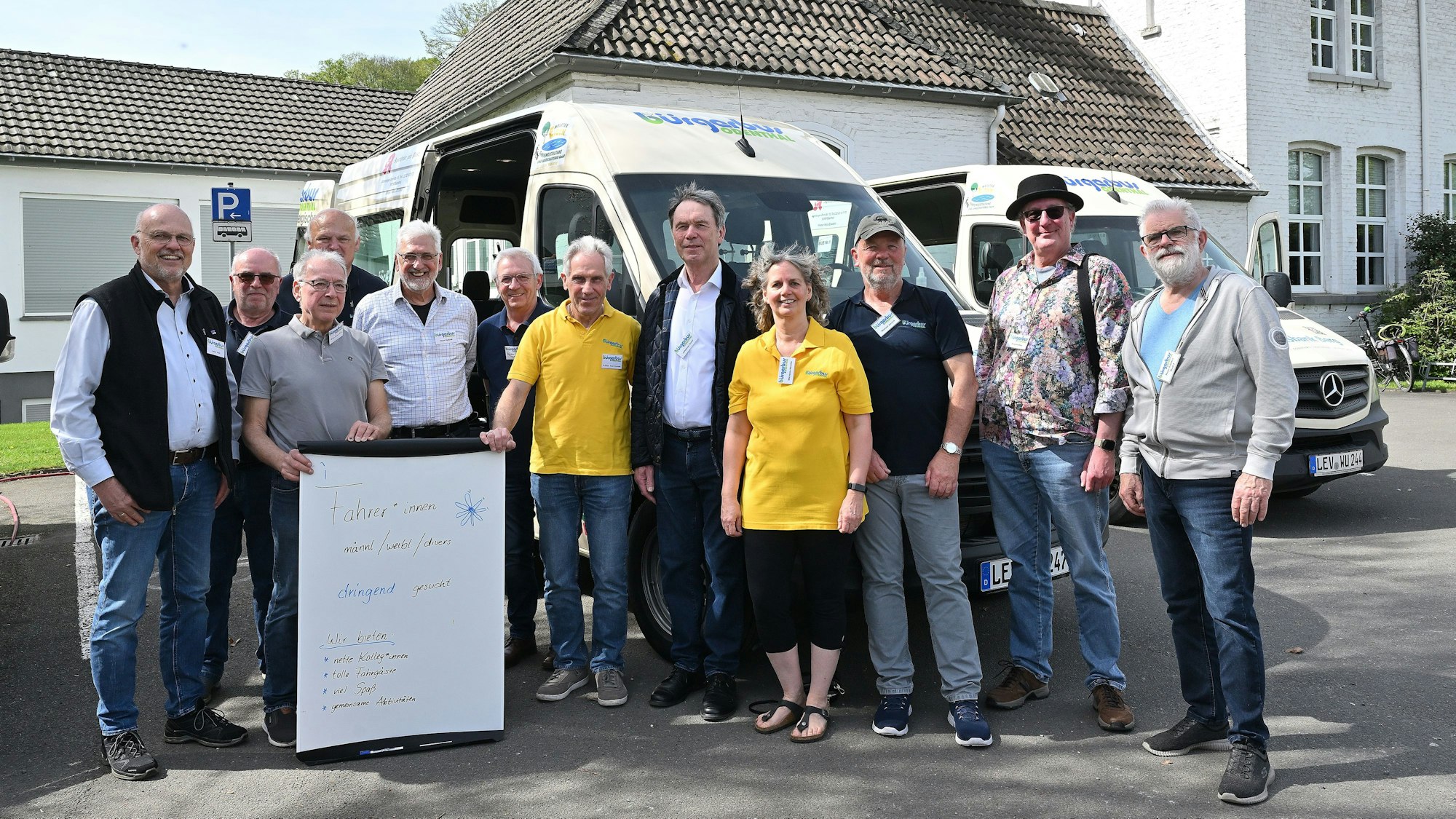 Viele Menschen stehen vor einem Kleinbus.