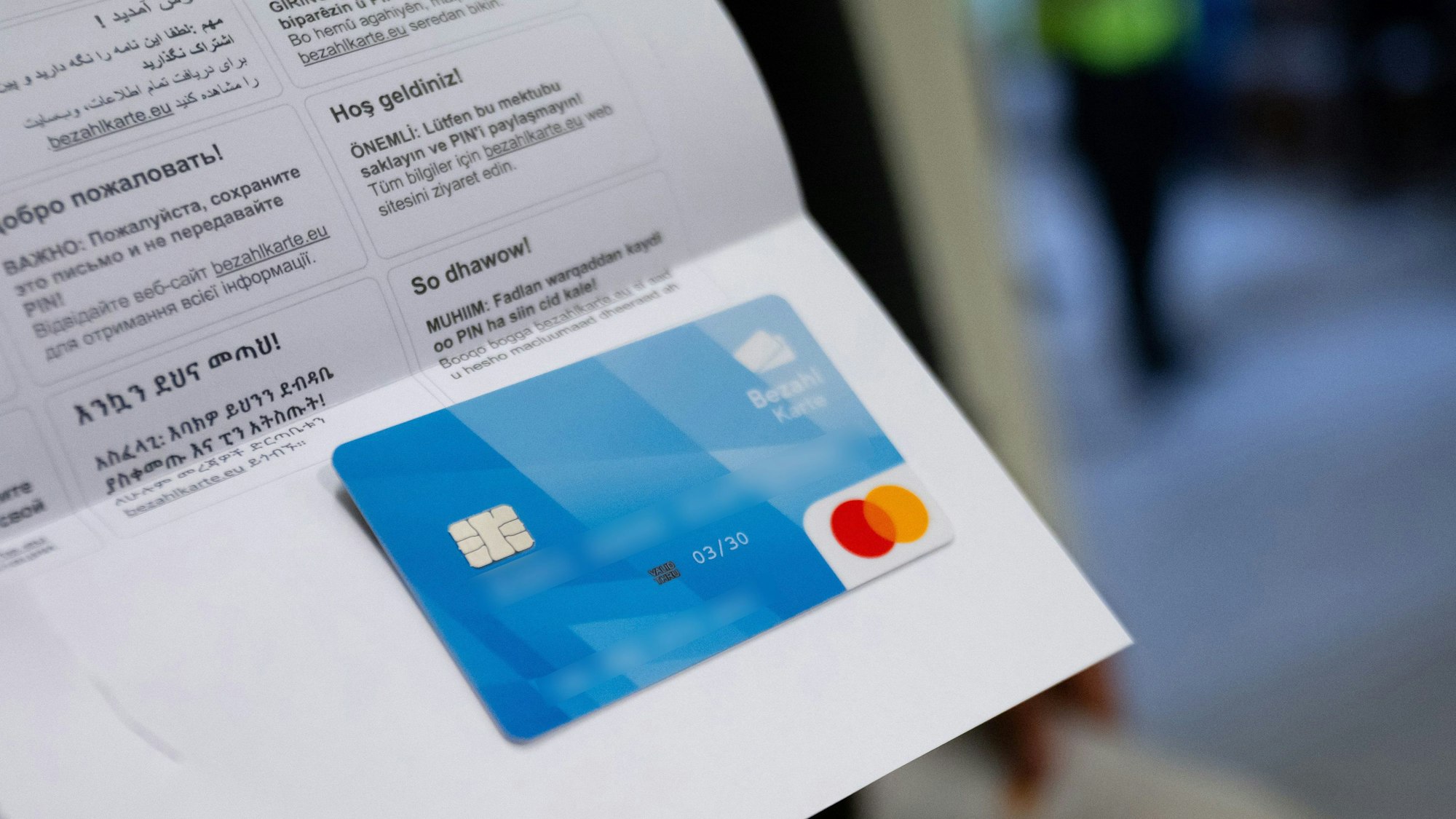 Bayern, Fürstenfeldbruck: Ein Asylbewerber zeigt im Ankerzentrum eine der ersten bayerischen Bezahlkarten die er zuvor erhalten hat.