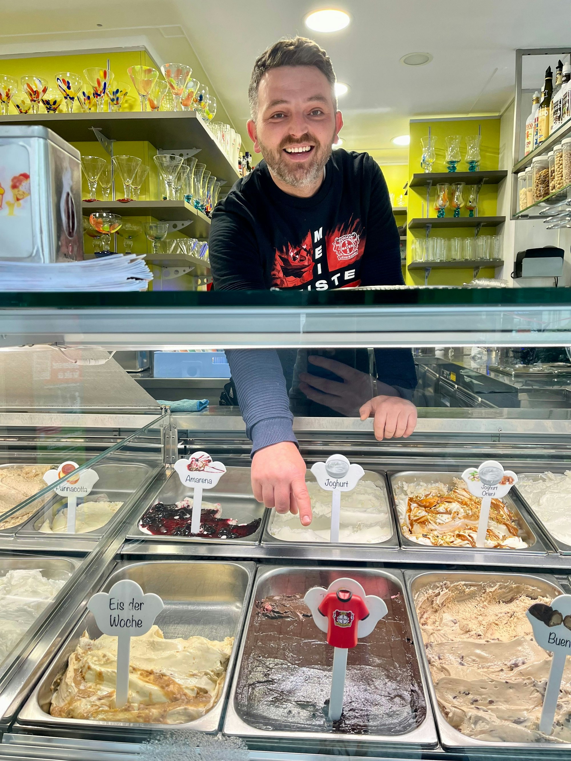 Jusuf Sinani serviert im Eiscafé Minini im Meister-Shirt das Meistereis