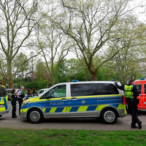 Polizisten und Streifenwagen stehen am Freitag, 12.04.2024, vor dem Gymnasium Kreuzgasse an der Vogelsanger Straße.