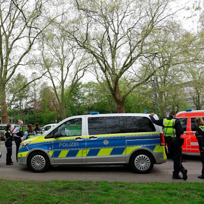 Polizisten und Streifenwagen stehen am Freitag, 12.04.2024, vor dem Gymnasium Kreuzgasse an der Vogelsanger Straße.