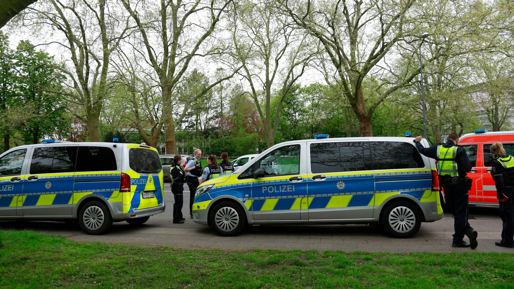 Polizisten und Streifenwagen stehen am Freitag, 12.04.2024, vor dem Gymnasium Kreuzgasse an der Vogelsanger Straße.