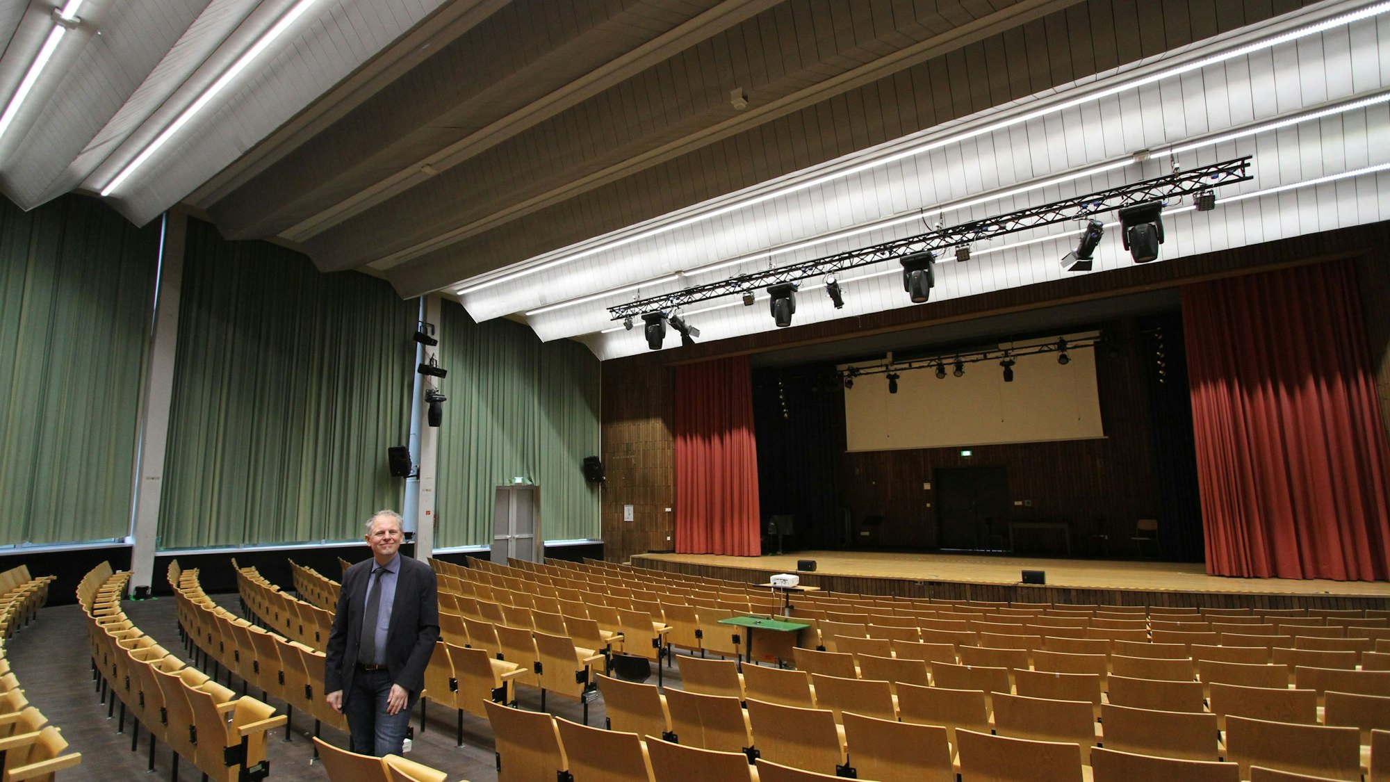 Schulleiter Sebastian Kaas in der wiedereröffneten Schulaula des Siegburger Anno-Gymnasiums
