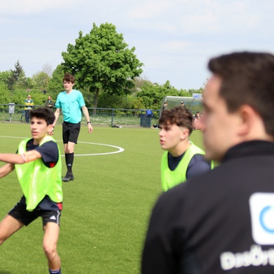 Arne Lichtenhagen beobachtet die Ausführung eines Einwurfs. Im Vordergrund unscharf ist Profi-Schiedsrichter Nico Fuchs zu sehen.