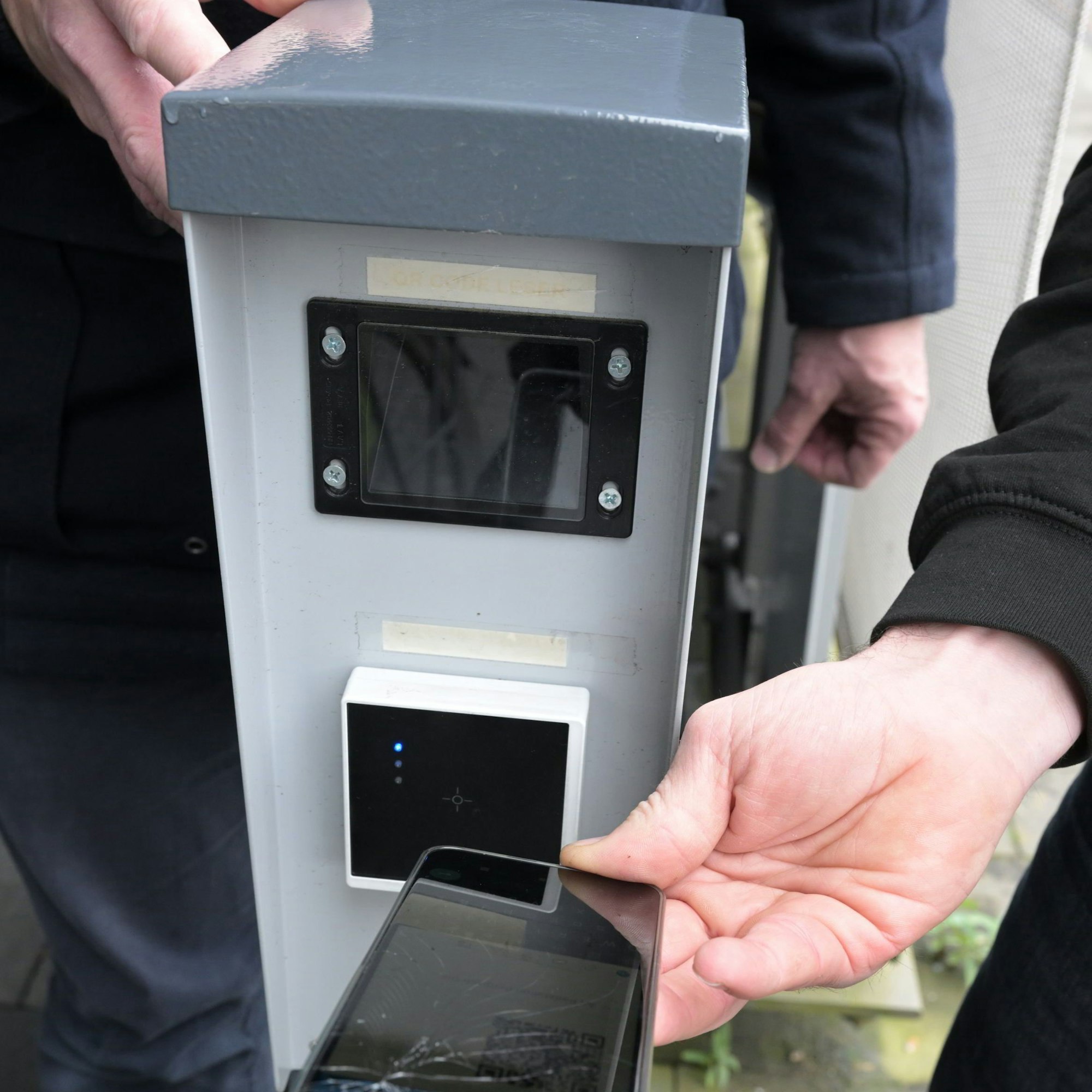 Das Handy mit dem QR-Code dient als Schlüssel, ein Lesergerät als Schloss.