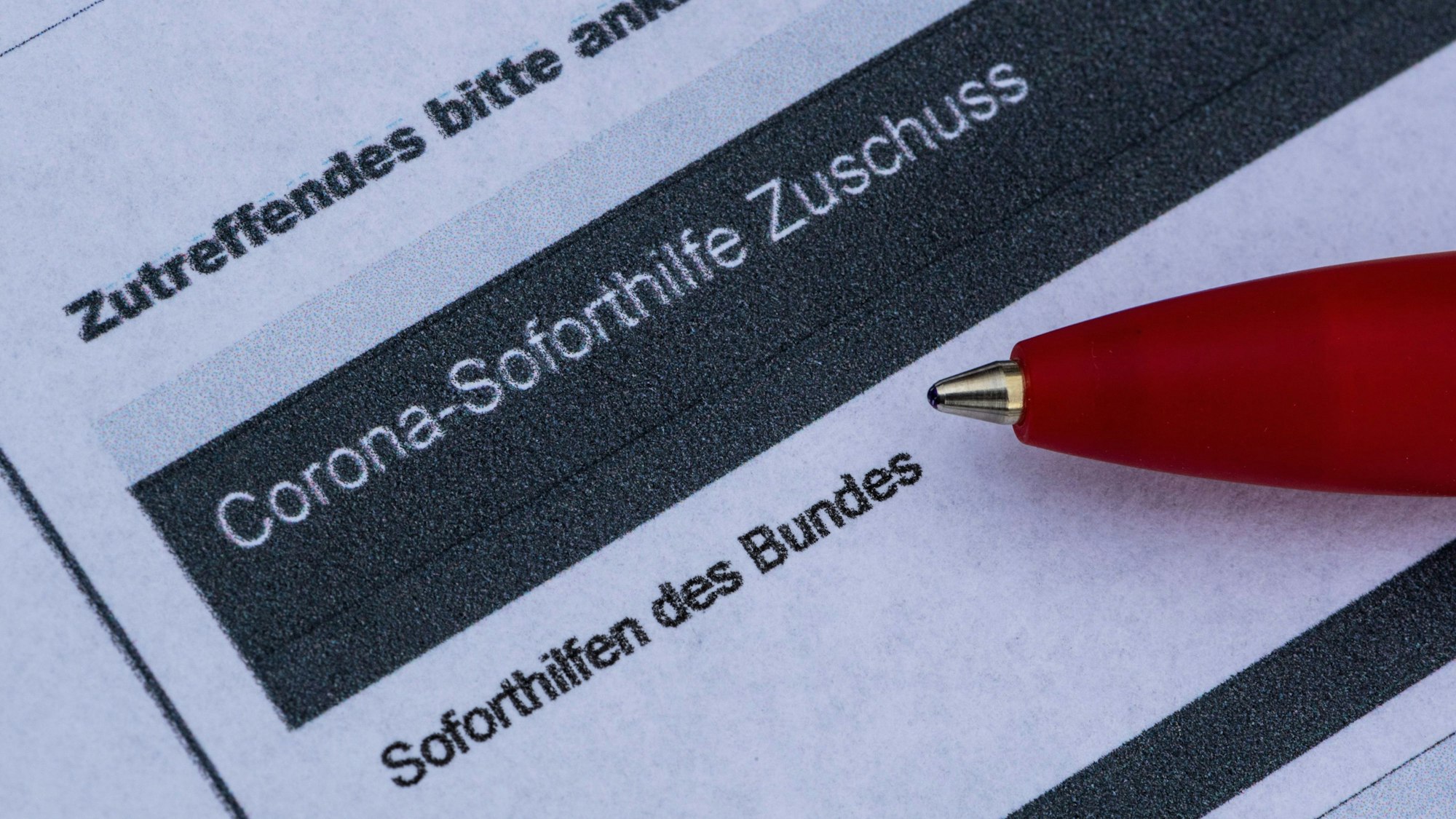 Ein Stift liegt auf einem Antrag für den Corona-Soforthilfe-Zuschuss. (Symbolbild)