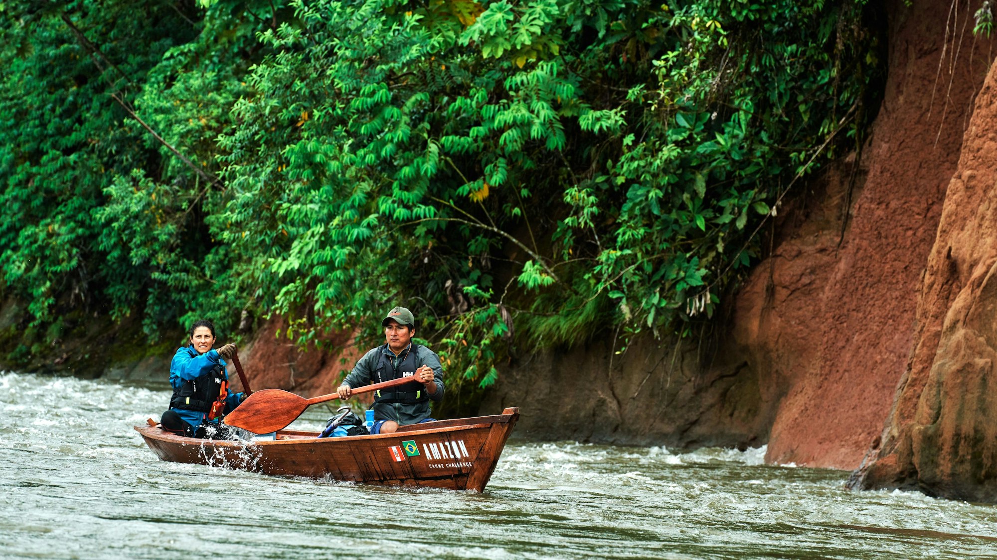 Ein Mann und eine Frau paddeln auf einem Fluss.