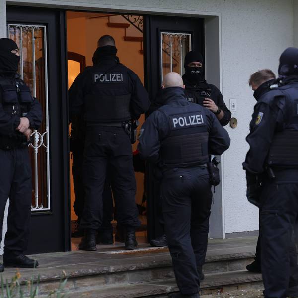 Polizeibeamte stehen an einem Gebäude, das durchsucht wird. Bei einer groß angelegten Razzia gegen eine international agierende Schleuserbande in acht Bundesländern hat die Staatsanwaltschaft Düsseldorf zehn Verdächtige verhaften lassen. Bei dem Einsatz waren seit dem frühen Morgen mehr als 1000 Beamte der Bundespolizei und der Staatsanwaltschaft beteiligt. Insgesamt wurden 101 Wohn- und Geschäftsräume durchsucht.