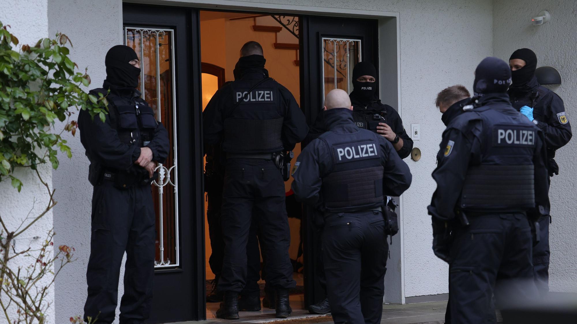 Polizeibeamte stehen an einem Gebäude, das durchsucht wird. Bei einer groß angelegten Razzia gegen eine international agierende Schleuserbande in acht Bundesländern hat die Staatsanwaltschaft Düsseldorf zehn Verdächtige verhaften lassen. Bei dem Einsatz waren seit dem frühen Morgen mehr als 1000 Beamte der Bundespolizei und der Staatsanwaltschaft beteiligt. Insgesamt wurden 101 Wohn- und Geschäftsräume durchsucht.