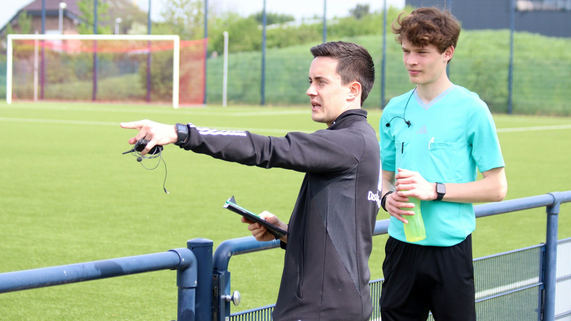 Um eine Szene zu verdeutlichen, zeigt Nico Fuchs in der Besprechung mit Arne Lichtenhagen auf einen Bereich des Sportplatzes.