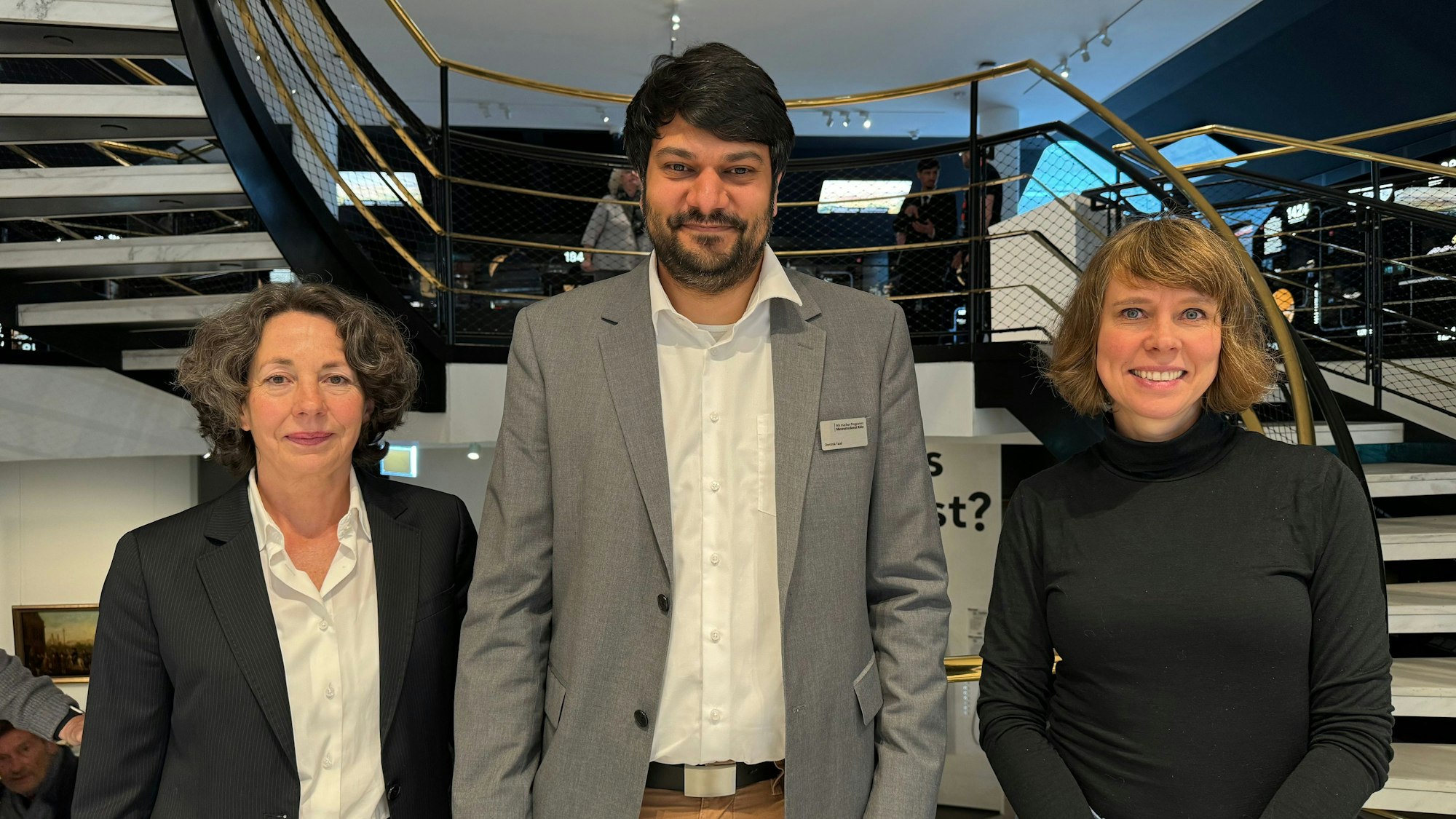 (von l. nach r.): Marie-Luise Höfling (Leitung „Medien und Öffentlichkeitsarbeit“ beim Museumsdienst), Dominik Fasel (Leitung „Programme Diversität und Museum“ beim Museumsdienst Köln) und Barbara Förster (Direktorin des Museumsdienstes Köln) stehen im Foyer des Kölnischen Stadtmuseums.