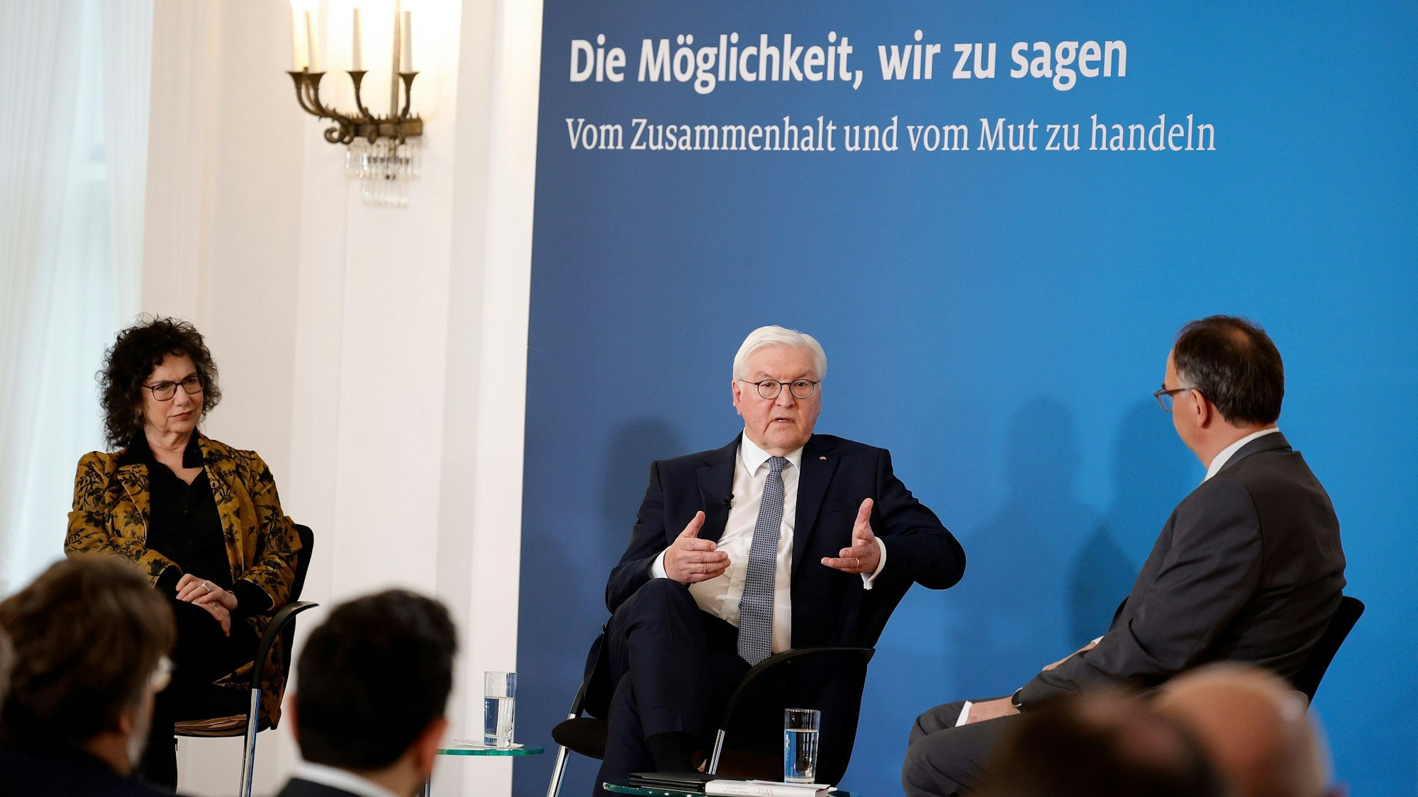Bundespräsident Frank-Walter Steinmeier (M) spricht mit Susan Neiman (l) und Nico Fried (r). Vor ihnen sitzt ein Publikum.