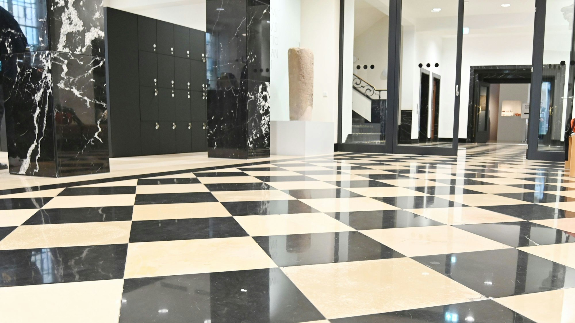 Schwarz-weißer Marmorboden glänzt im Foyer des Maison Belge.